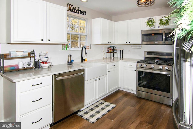 kitchen featuring light countertops, decorative backsplash, white cabinets, and stainless steel appliances
