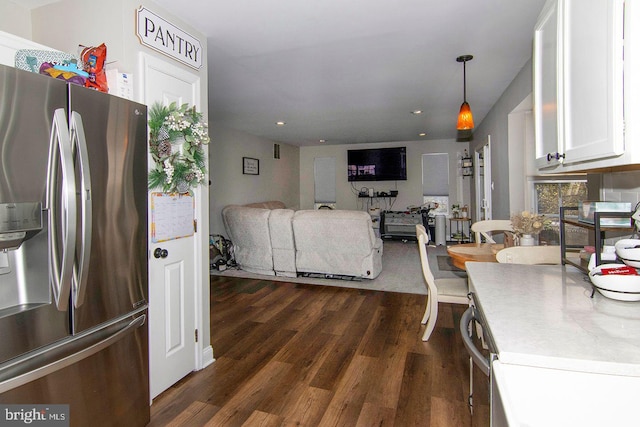 kitchen featuring hanging light fixtures, dark wood finished floors, stainless steel fridge, recessed lighting, and white cabinetry