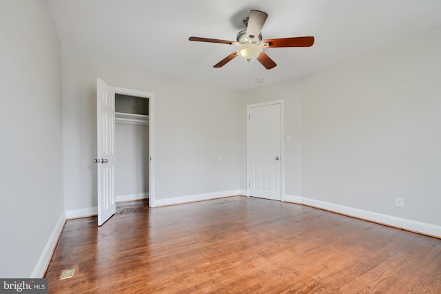 unfurnished bedroom with wood finished floors, baseboards, a closet, and ceiling fan