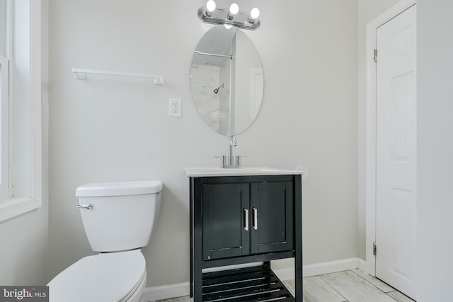 bathroom featuring toilet, baseboards, vanity, and marble finish flooring
