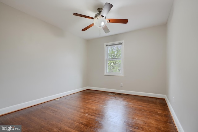 spare room with baseboards, wood finished floors, and ceiling fan