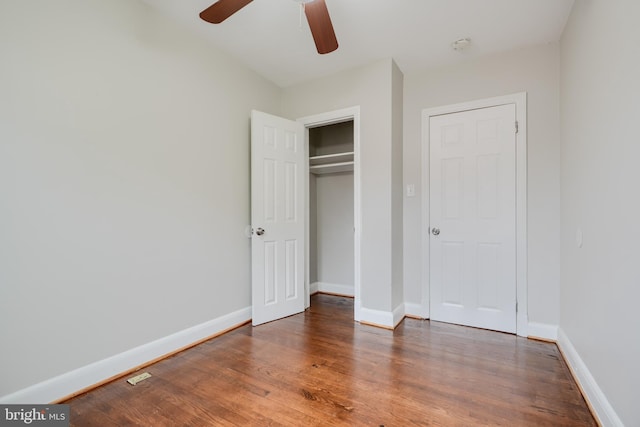 unfurnished bedroom featuring wood finished floors, baseboards, a closet, and a ceiling fan