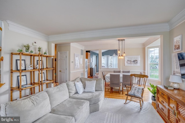 living area featuring light wood-style flooring and ornamental molding