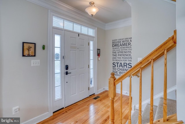entrance foyer featuring visible vents, wood finished floors, stairs, and crown molding