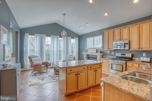 kitchen with light tile patterned floors, vaulted ceiling, appliances with stainless steel finishes, and a healthy amount of sunlight