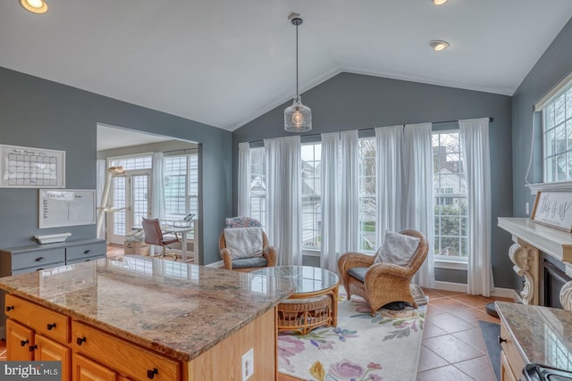 interior space featuring a center island, light tile patterned flooring, vaulted ceiling, pendant lighting, and light stone counters