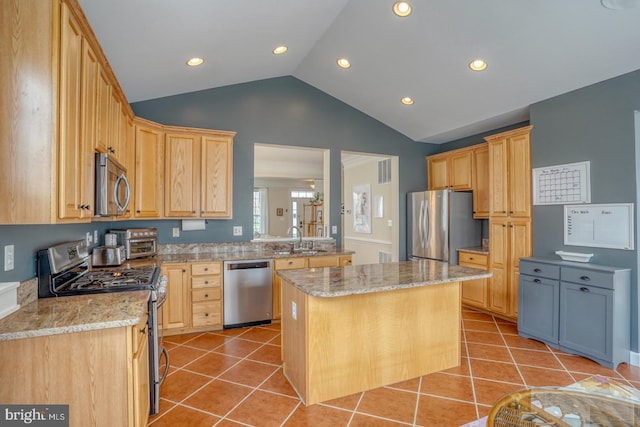 kitchen featuring light brown cabinetry, light tile patterned floors, stainless steel appliances, and a sink