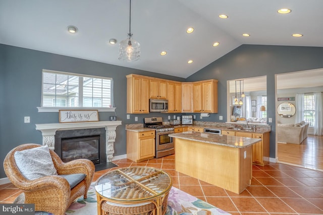 kitchen featuring light brown cabinetry, a sink, appliances with stainless steel finishes, and light tile patterned flooring