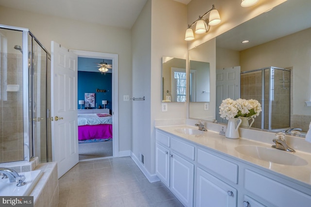 ensuite bathroom with tile patterned floors, a stall shower, and a sink
