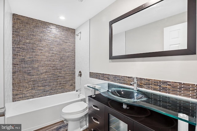 bathroom featuring recessed lighting, toilet, vanity, decorative backsplash, and shower / bathing tub combination
