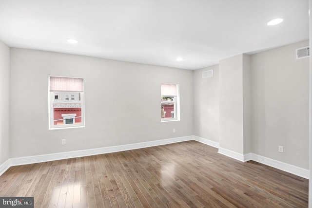 unfurnished room featuring baseboards, recessed lighting, visible vents, and wood finished floors
