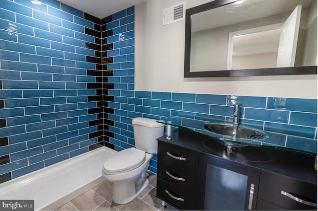 bathroom featuring tile walls, toilet, visible vents, a shower stall, and vanity