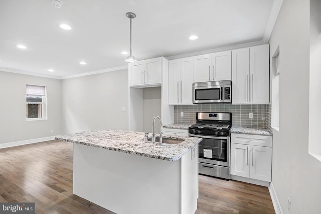 kitchen featuring a sink, wood finished floors, ornamental molding, baseboards, and appliances with stainless steel finishes