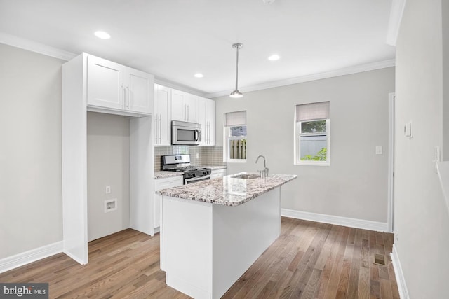 kitchen with light wood-type flooring, white cabinetry, appliances with stainless steel finishes, and a sink