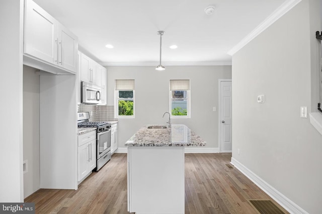 kitchen with a sink, crown molding, white cabinets, and appliances with stainless steel finishes