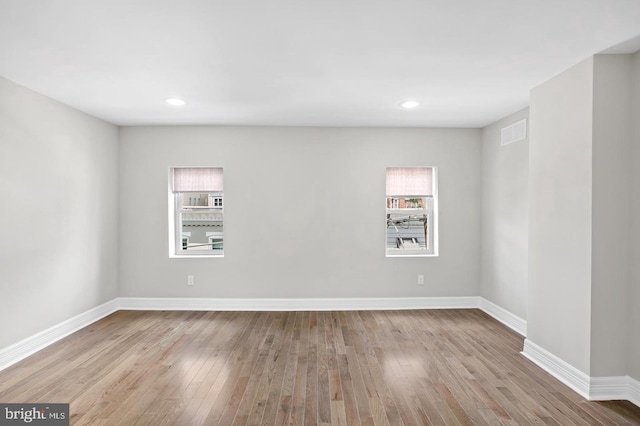 spare room with recessed lighting, baseboards, and wood finished floors