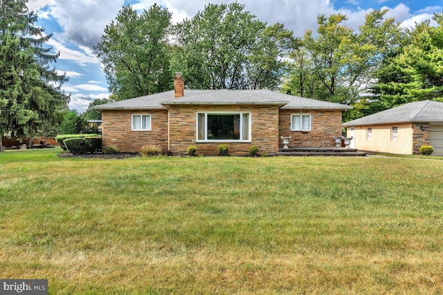 view of front of property featuring stone siding, a front lawn, and a chimney