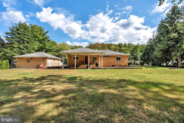 rear view of house featuring a lawn and brick siding