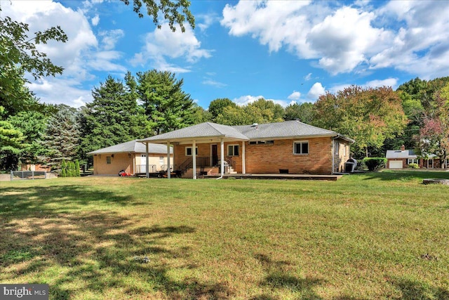 back of house featuring brick siding, a yard, and a porch