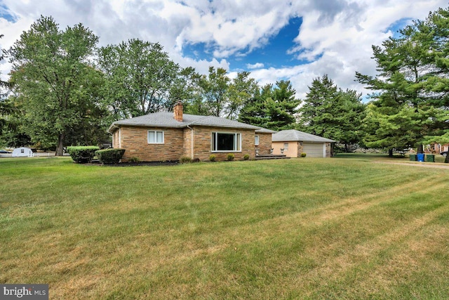 exterior space featuring a chimney, a front lawn, and a detached garage