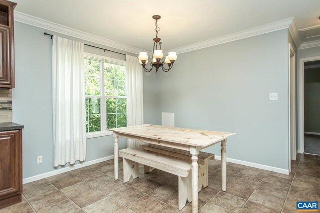 dining area featuring a notable chandelier, baseboards, and ornamental molding