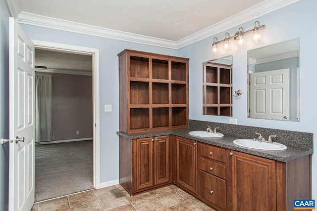 bathroom featuring tile patterned flooring, double vanity, crown molding, and a sink