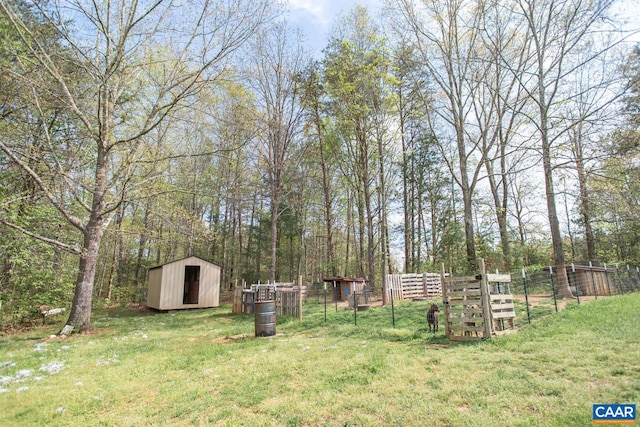 view of yard with fence, an outbuilding, and a storage unit