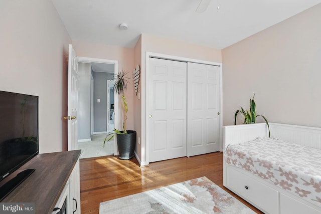 bedroom featuring wood finished floors, ceiling fan, and a closet