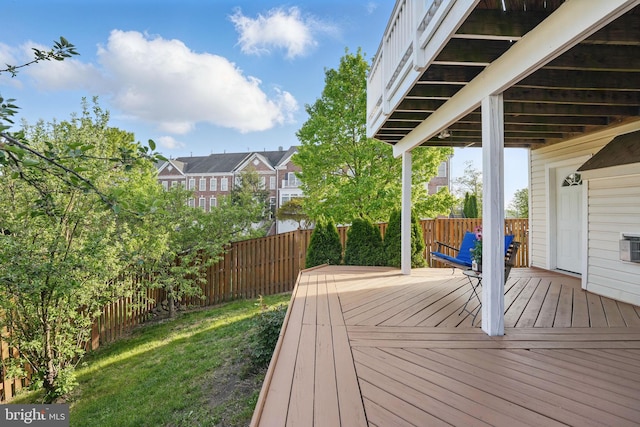 wooden terrace with fence, a yard, and a residential view