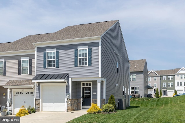 view of front of house featuring cooling unit, concrete driveway, an attached garage, stone siding, and a front yard