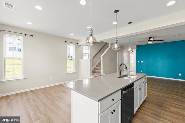 kitchen with a sink, open floor plan, baseboards, recessed lighting, and light wood-style floors