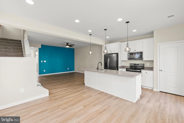 kitchen with white cabinets, stainless steel appliances, and light wood-style flooring