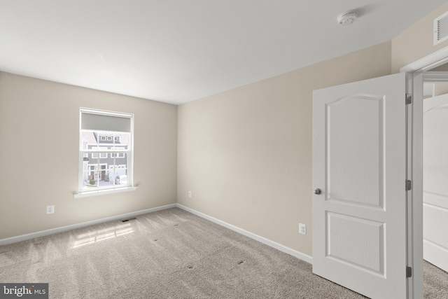 spare room with visible vents, carpet flooring, and baseboards