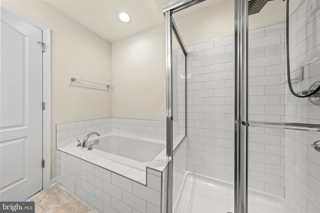 bathroom with recessed lighting, a bath, tile patterned flooring, and a stall shower
