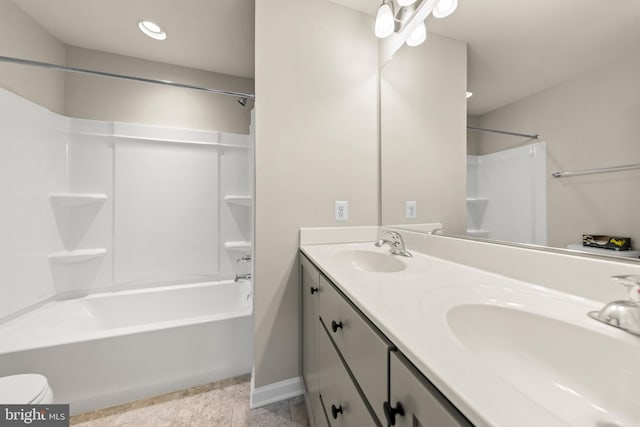 bathroom featuring baseboards, a sink, tub / shower combination, and double vanity