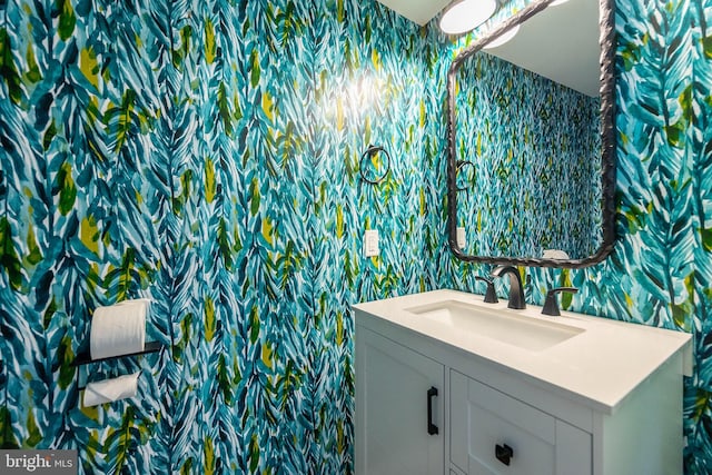 bathroom featuring vanity and wallpapered walls