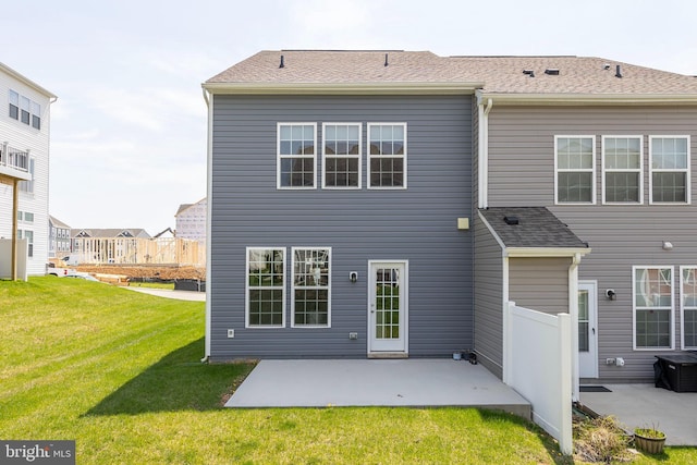 rear view of property featuring fence, a yard, a patio, and a shingled roof