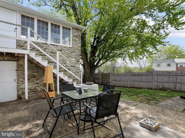 view of patio / terrace with fence, stairs, and outdoor dining space