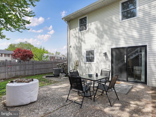 view of patio featuring outdoor dining space, central AC unit, and fence
