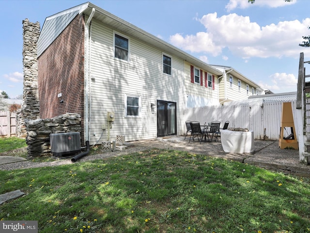 rear view of property featuring a yard, central air condition unit, a patio, and fence