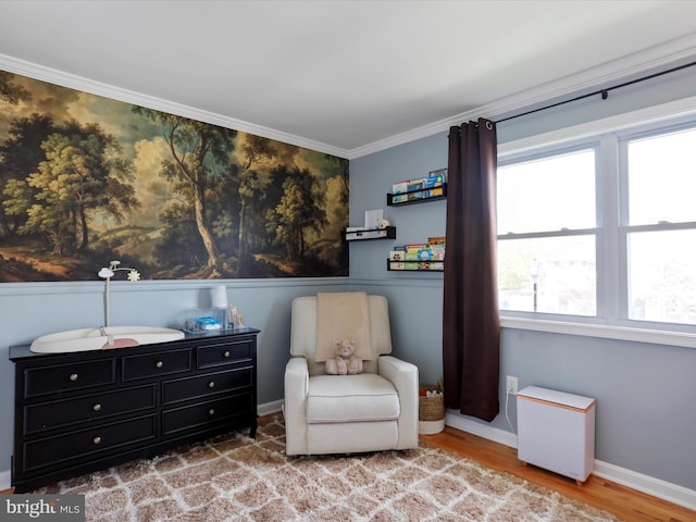 sitting room with baseboards, wood finished floors, and crown molding