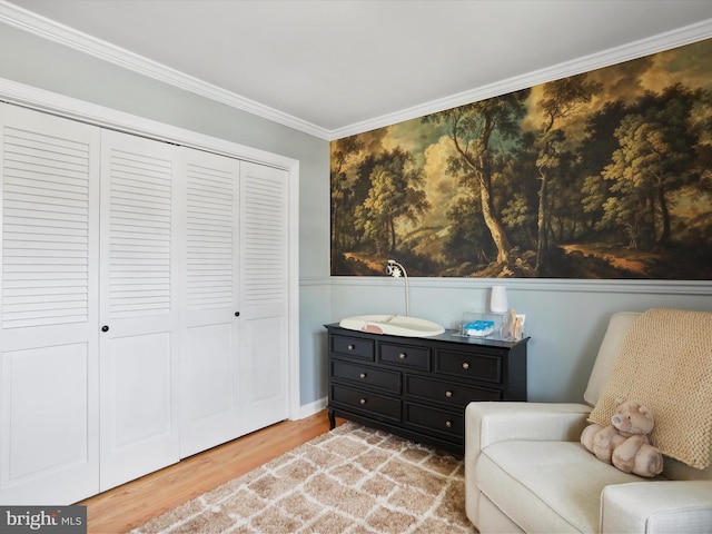 living area featuring wainscoting, crown molding, and wood finished floors