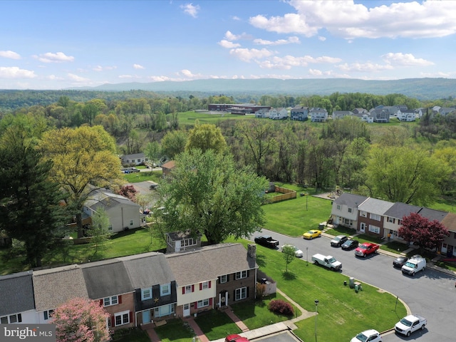 drone / aerial view with a wooded view and a residential view