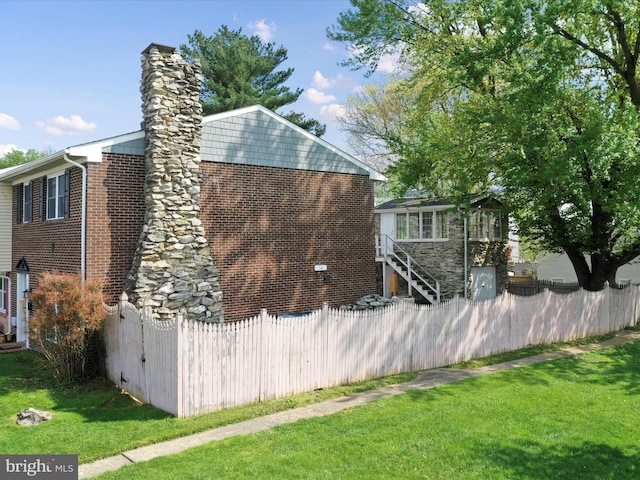 view of property exterior featuring a yard, a chimney, and fence