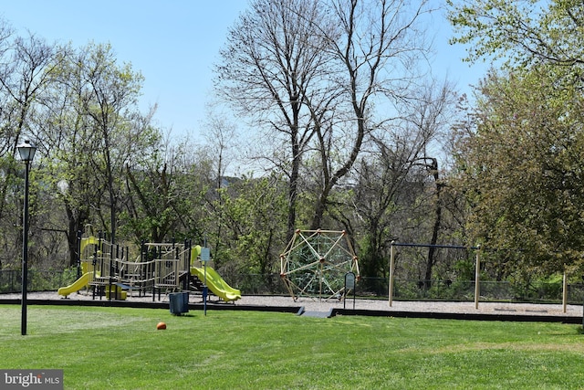 community play area with fence and a yard