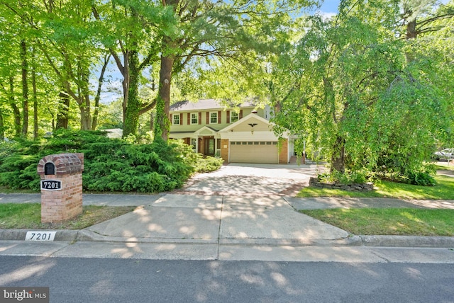 view of front of property with an attached garage, brick siding, and concrete driveway