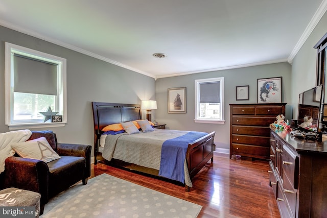 bedroom featuring baseboards, visible vents, ornamental molding, and dark wood finished floors
