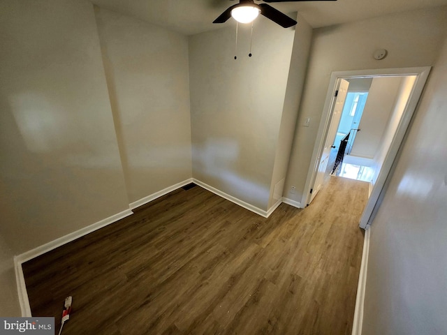 spare room with baseboards, wood finished floors, and ceiling fan