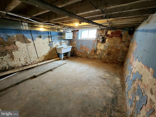 basement featuring electric panel and a sink