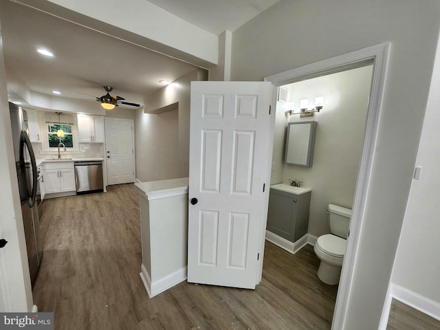 interior space featuring dark wood finished floors, baseboards, a sink, and recessed lighting